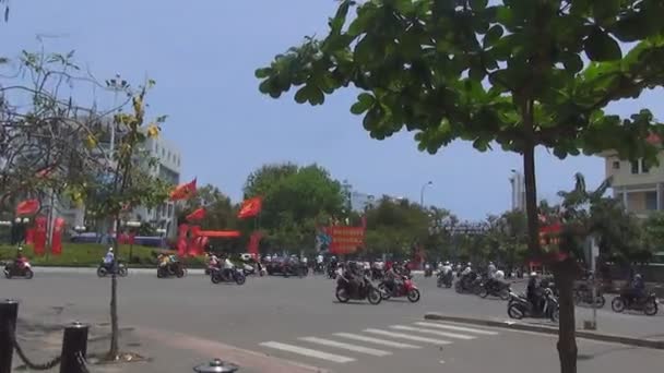 Motocykly, rikši a autobusy jezdí úzkými uličkami z Vietnamu. Slavnostní vlajka vlaje na náměstí — Stock video