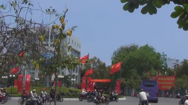 Chaotická doprava na kruhu, červené vlajky jsou vyvíjeny ve větru, slavnostní náladu — Stock video