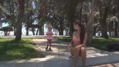 Kaldırıma mesafe bebek aşağı. Annesi ona yardımcı olur.