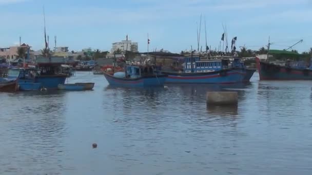Modré vietnamské lodě kotvící na řece. červené vlajky jsou vyvíjeny ve větru. — Stock video