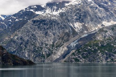 Alaska Buzul Körfezi 'nde bulutlu gökyüzü olan dağlar ve okyanuslar