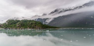 Alaska Buzul Körfezi 'nde bulutlu gökyüzü olan dağlar ve okyanuslar