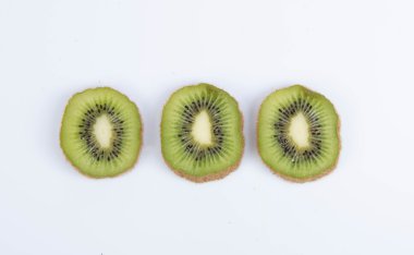 beyaz zemin üzerine dilimlenmiş olgun kivi ile natürmort