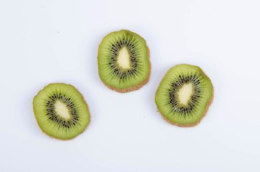 beyaz zemin üzerine dilimlenmiş olgun kivi ile natürmort