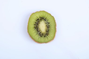 beyaz zemin üzerine dilimlenmiş olgun kivi ile natürmort