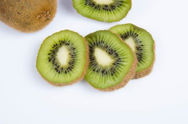 beyaz zemin üzerine dilimlenmiş olgun kivi ile natürmort