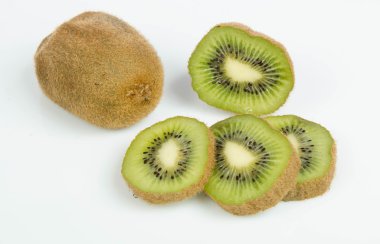 beyaz zemin üzerine dilimlenmiş olgun kivi ile natürmort