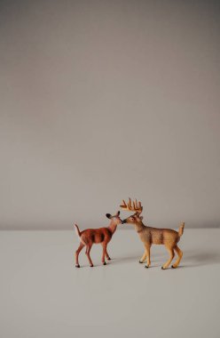 Ayakta duran güzel ren geyikleri. Plastikten ya da plastikten yapılmış küçük bir oyuncak. Çocukların oynaması için mükemmel bir oyuncak. Arka plan bulanık. aile ren geyiği