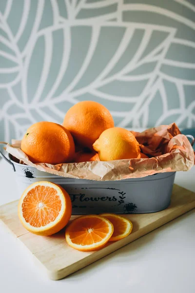 Taze portakallar ve limonlar masada kırsal bir kasede.