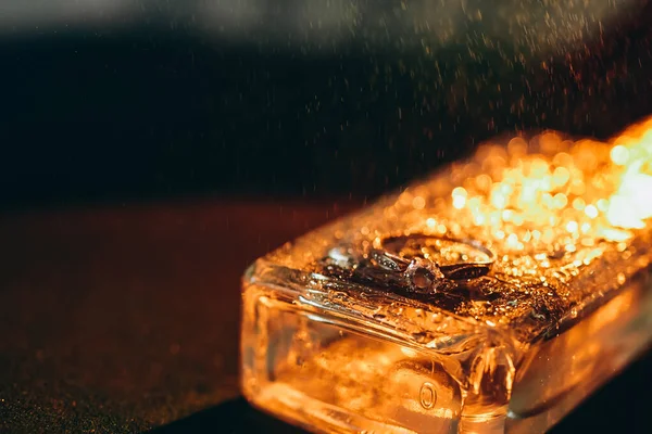 Altın renkli alyans, siyah arka planda pırlanta parlatmalı.