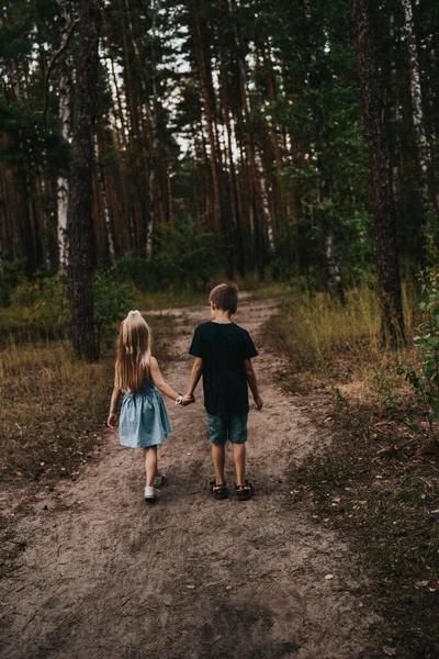 girl and boy holding hands in the forest