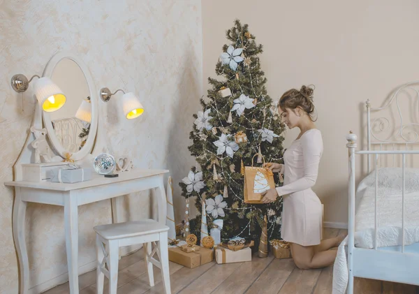 La muchacha cerca del árbol de Navidad con los regalos — Foto de Stock