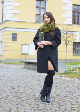 bir kitap ile sokakta kız yürüyor