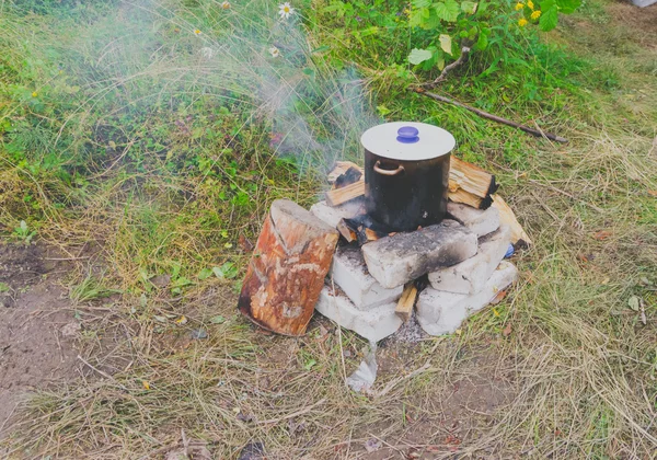 Na panela da floresta com tampa a comida é cozida no fogo — Fotografia de Stock