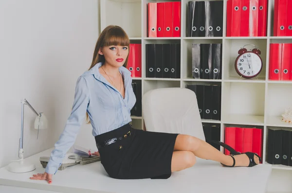 Beautiful girl sitting on the table — Stock Photo, Image