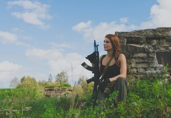La chica soldado mirando a la distancia de pie junto a la pistola —  Fotos de Stock