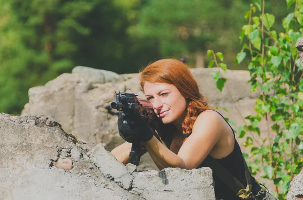 Hermosa chica militar apuntando un arma basada en la cubierta de hormigón —  Fotos de Stock