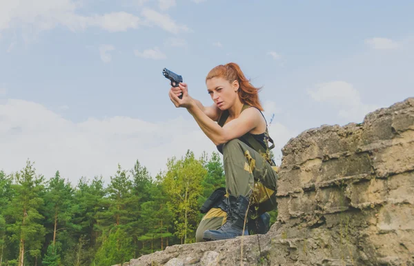 Flicka i statlig form att sikta med en pistol — Stockfoto