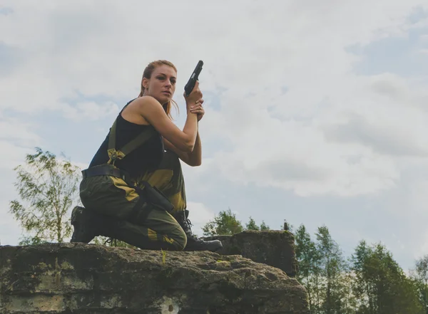 Menace belle fille en uniforme avec un pistolet — Photo