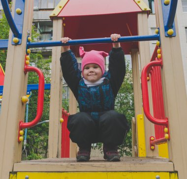 Çocuk parkta oynarken engellerin üstesinden gelir.