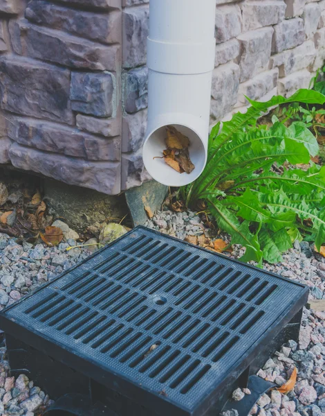 Tubo per il drenaggio dell'acqua piovana con foglie autunnali all'interno — Foto Stock