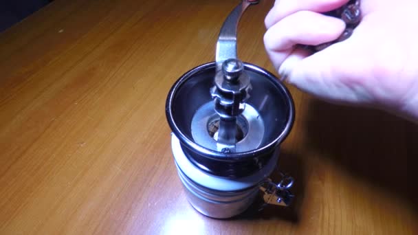 The hand twists the handle of a mechanical coffee grinder — Stock Video