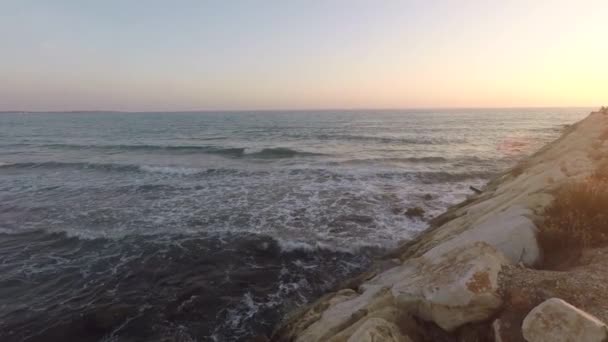De rotsachtige golven in zee en zonsondergang — Stockvideo