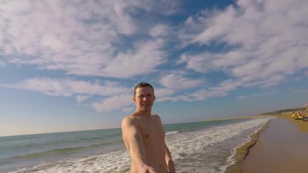 De man op de achtergrond van de zee neemt een selfie — Stockvideo