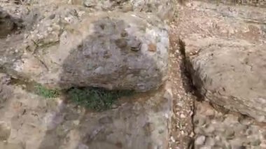 Turist gölgeyi takip ederek kayalıklarda yürüyor.