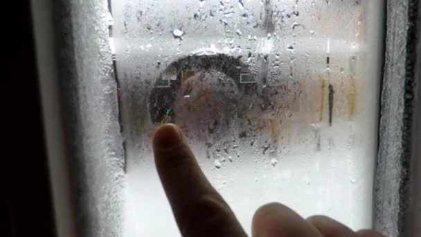 Iarna desenez o inimă pe fereastra cețoasă cu degetul — Videoclip de stoc