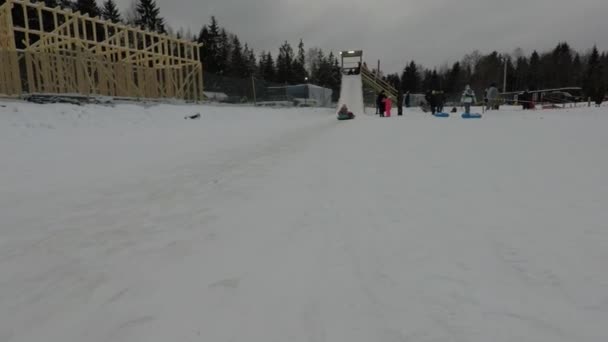 Зима щаслива дитина ковзає по пагорбу — стокове відео