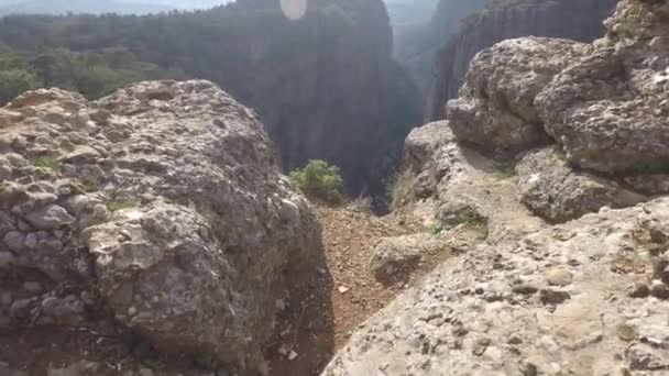 Pohled první osoby na muže, který kráčí k okraji hlubokého velkého kaňonu — Stock video