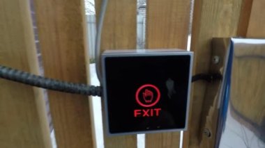 Adam sokak kapısındaki çıkış düğmesine eliyle basıyor.