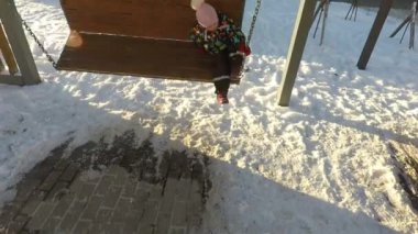 Kış bir çocuk zincir salıncakta sallanır
