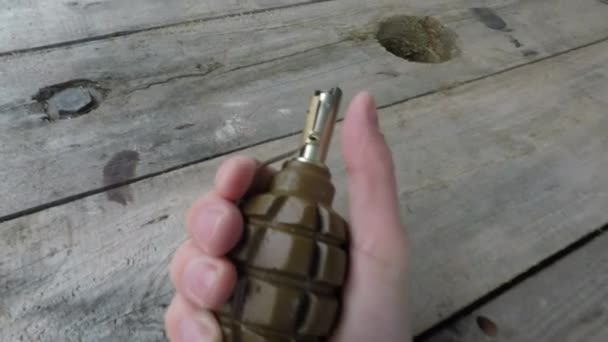 The hand with grenade releases the safety catch — Stock Video