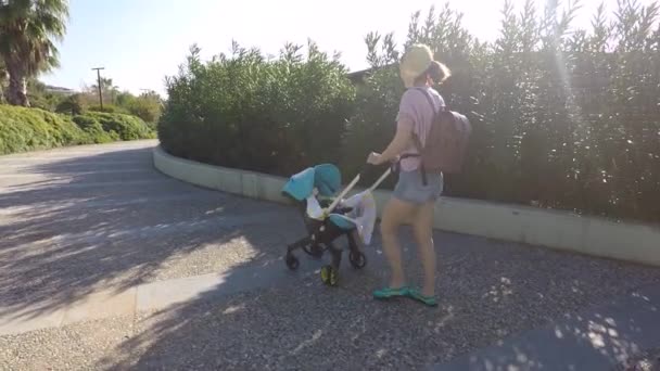 Sommardagen mor promenader med ett barn i en barnvagn — Stockvideo