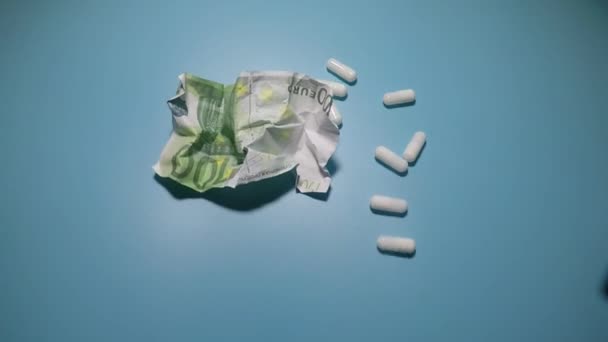 O close-up de dinheiro e pílulas na mesa é tomado por um homem — Vídeo de Stock