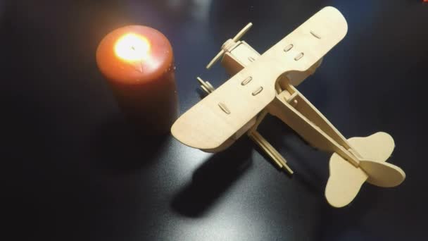L'aereo di legno di sfondo nero e una candela estinta — Video Stock