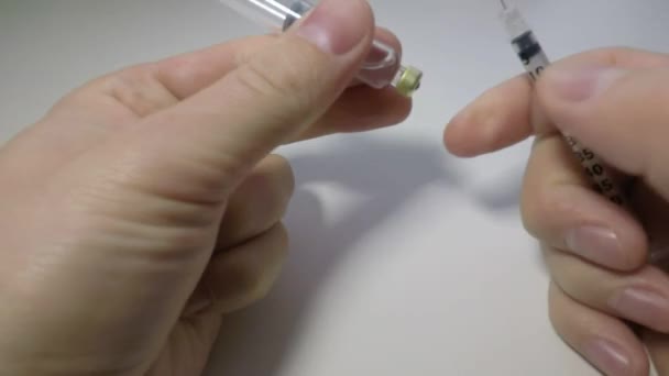 Il primo piano delle mani che prendono il medicinale da una fiala in una siringa — Video Stock