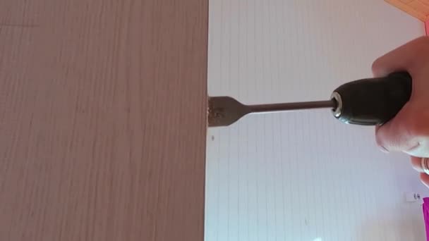 El trabajador utiliza un taladro para hacer un agujero de cerradura en la puerta — Vídeos de Stock