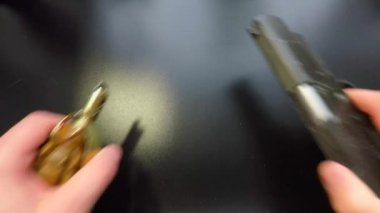El bombası ve tabanca siyah masaya konur.