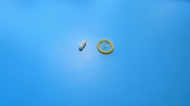 De blauwe tafel is er een keuze uit voorbehoedsmiddelen een condoom of een pil — Stockvideo