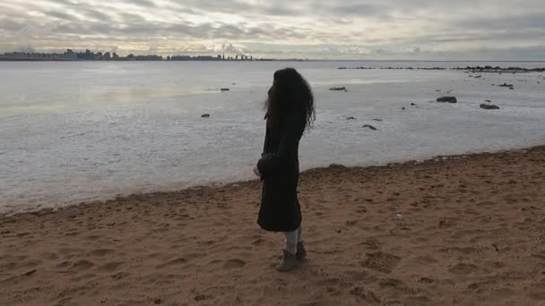 Dívka v zimě u moře na písečné pláži — Stock video