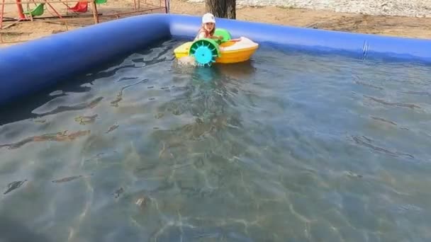 Slunečný letní den dítě dívka na vodě atrakce loď — Stock video