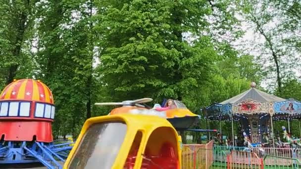 The children in the amusement park ride on the carousel — Stock Video