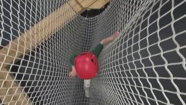 A criança supera obstáculos em um parque de corda — Vídeo de Stock