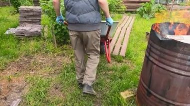 Bahçedeki el arabası ve küreği olan kız.