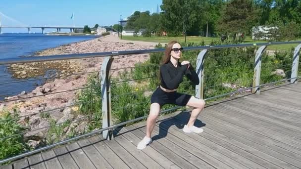 A menina fazendo fitness nos agachamentos exercício aterro — Vídeo de Stock