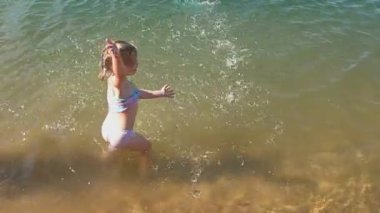 Kız çocuğu güneşli bir günde suda yüzüyor.