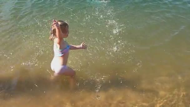 Девочка плавает в воде в солнечный теплый день — стоковое видео